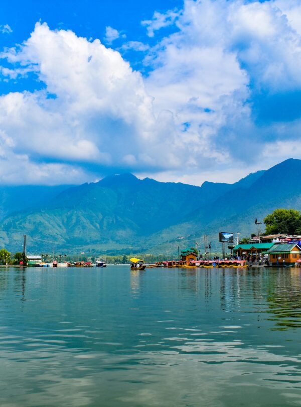 Explore the stunning Dal Lake in Kashmir with the majestic Himalayas in the background.