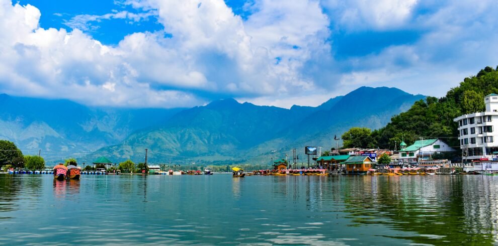 Explore the stunning Dal Lake in Kashmir with the majestic Himalayas in the background.