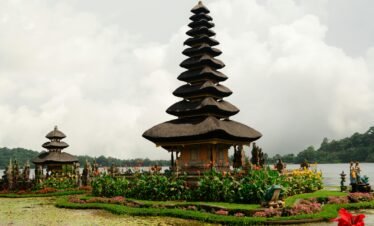 Pura Ulun Danu Beratan on tranquil Lake Bratan amidst scenic flora in Bali, Indonesia.